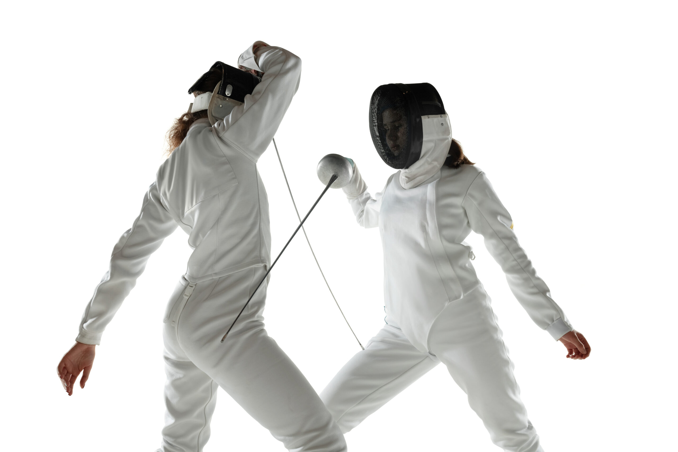 Teen girls in fencing costumes with swords in hands isolated on white background